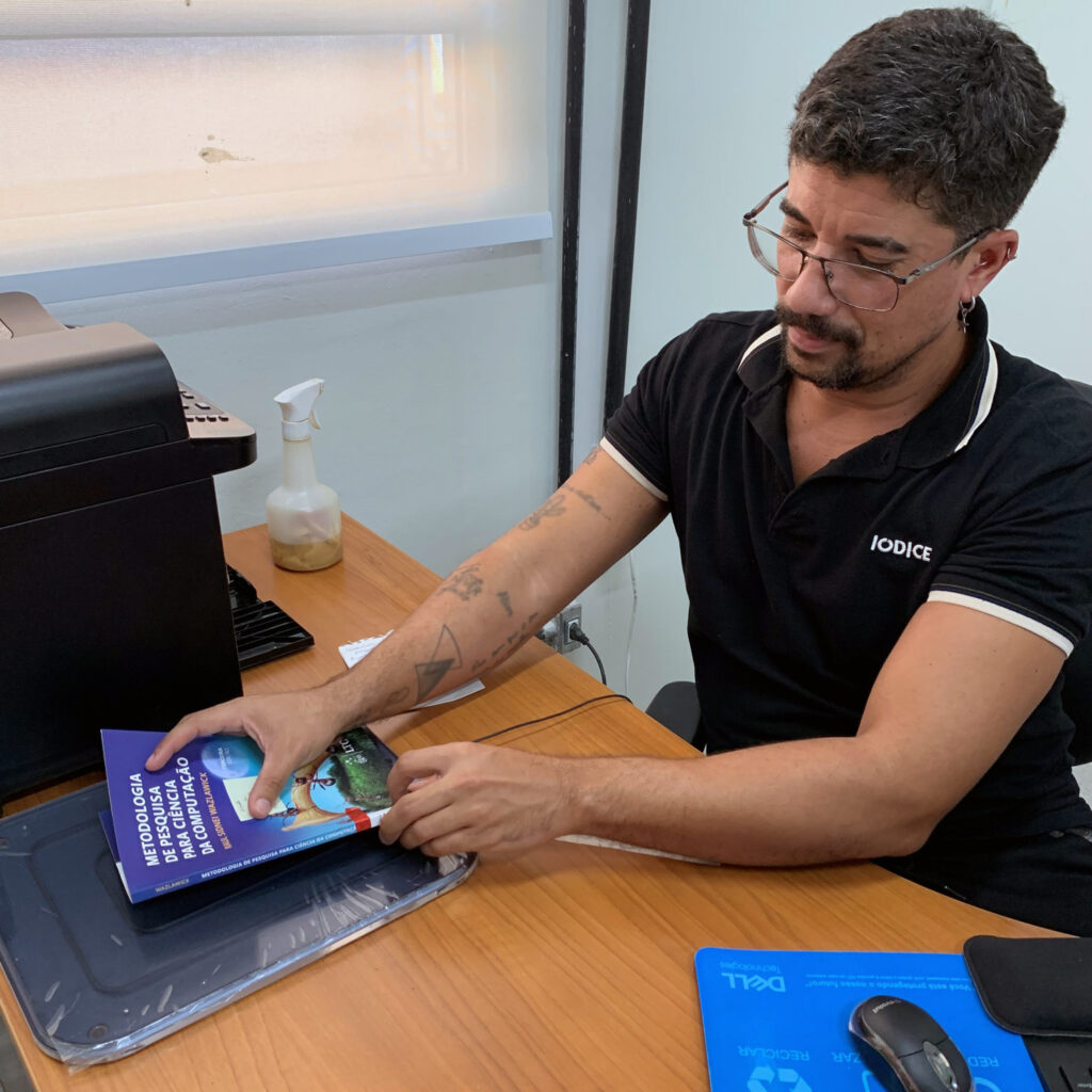 IFPE library staff desensitizing a book