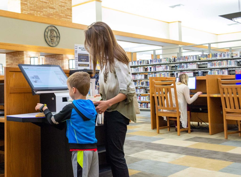 Mother and son using selfcheck500 in Sioux Center library