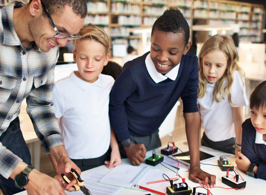 Teacher and children learning STEM in a library