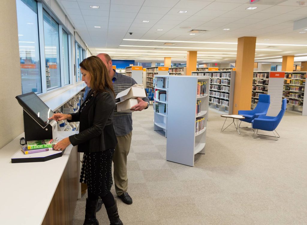 Women and Man checking out books at the selfcheck 500D