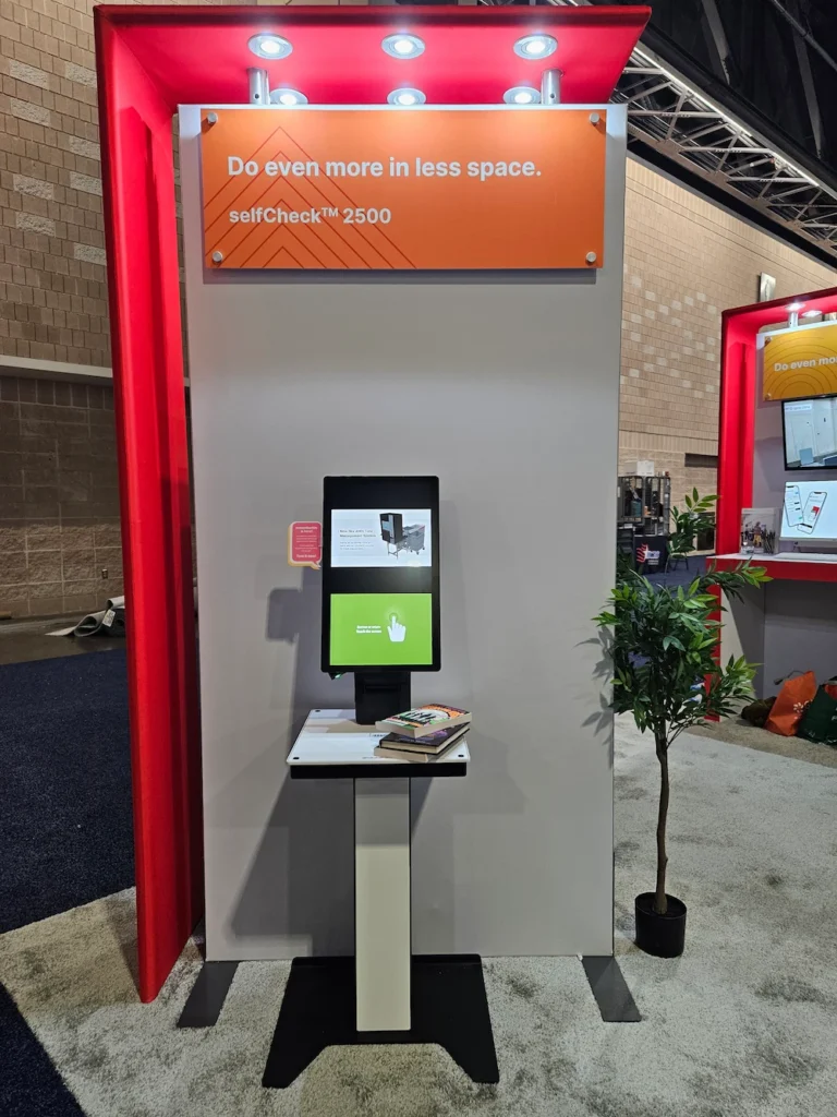 selfCheck 2500 kiosk displayed at ALA 2025, showcasing compact design with touchscreen and books on counter