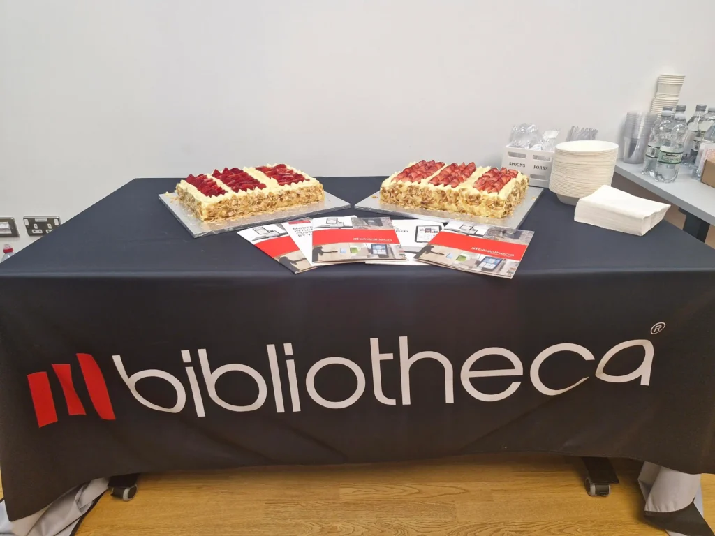 Attendees celebrating the conclusion of the Bibliotheca North Roadshow at The Stockroom with a cake
