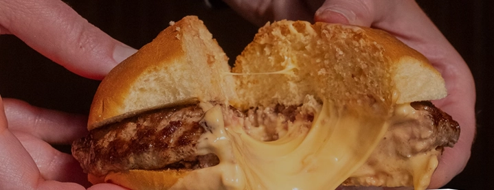 Close-up of a Juicy Lucy burger cut open to reveal melted cheese inside, Minneapolis’ most famous comfort food.
